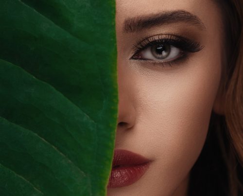woman in red lipstick beside green textile