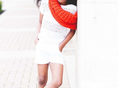 smiling girl in white shirt and shorts wearing red scarf during daytime