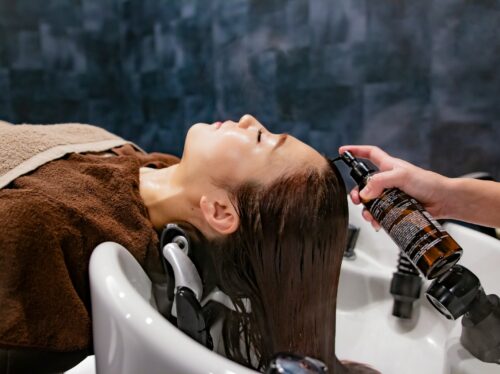 a woman getting her hair washed in a sink